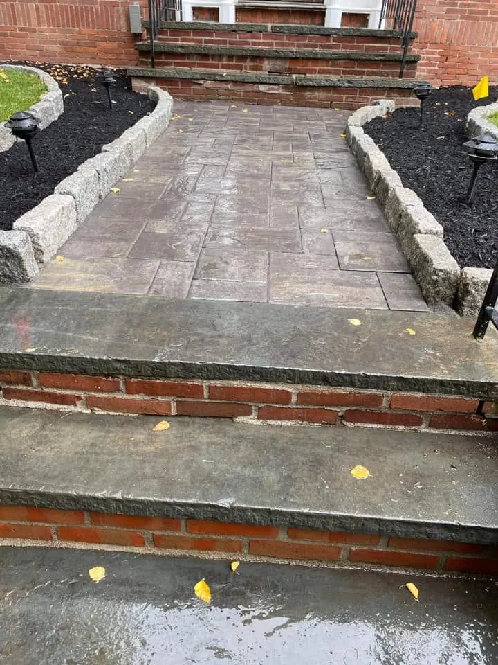 Paver landing and steps with fresh mulch beds at a brick entry