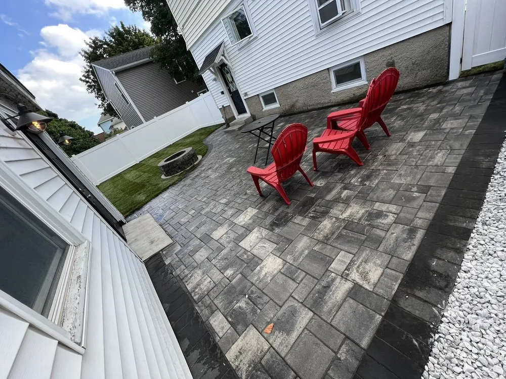 Paver patio with a fire pit and red Adirondack chairs
